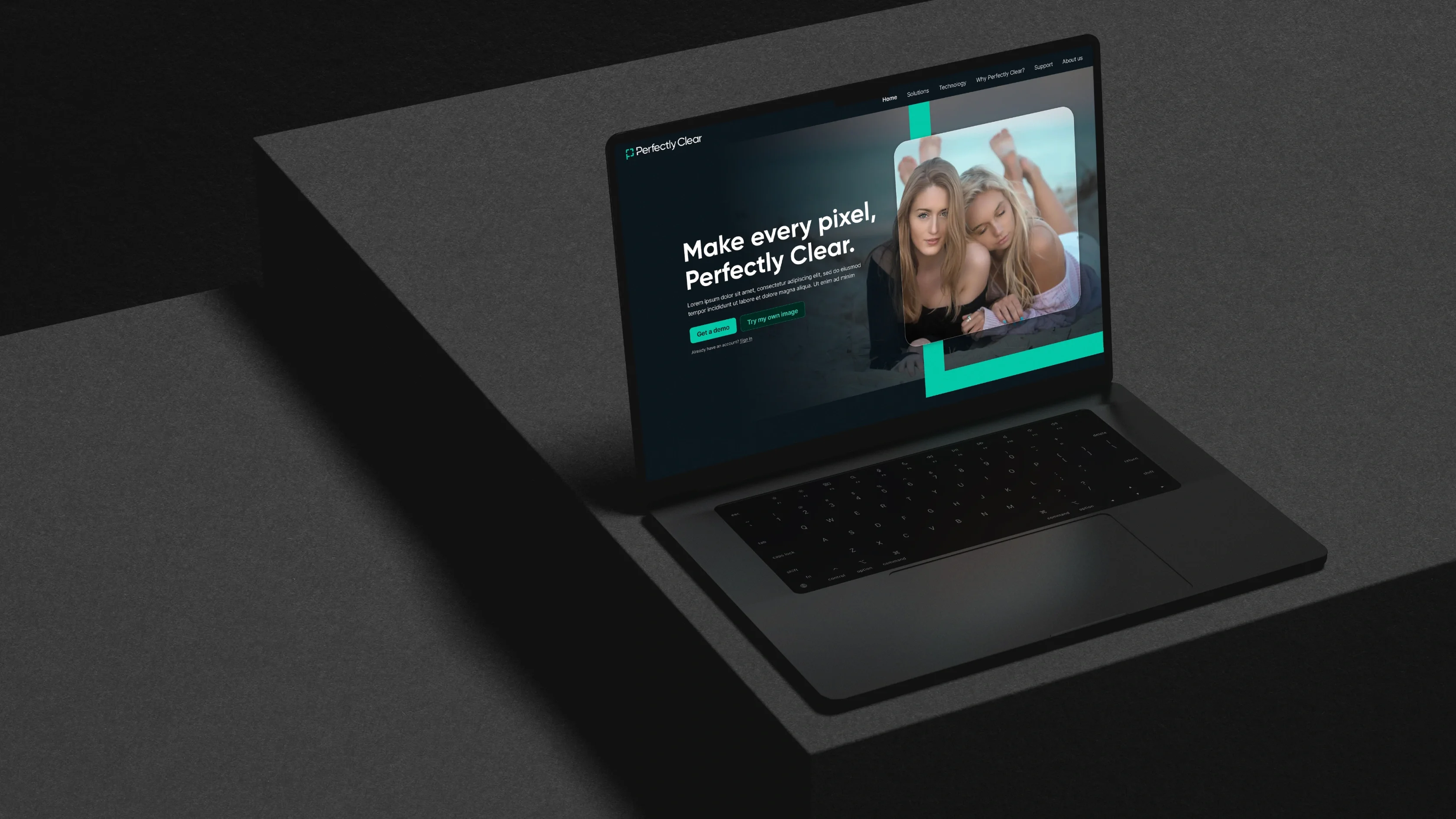 A black laptop on a dark surface displays the Perfectly Clear website, showcasing strong brand identity and a photo of two women.