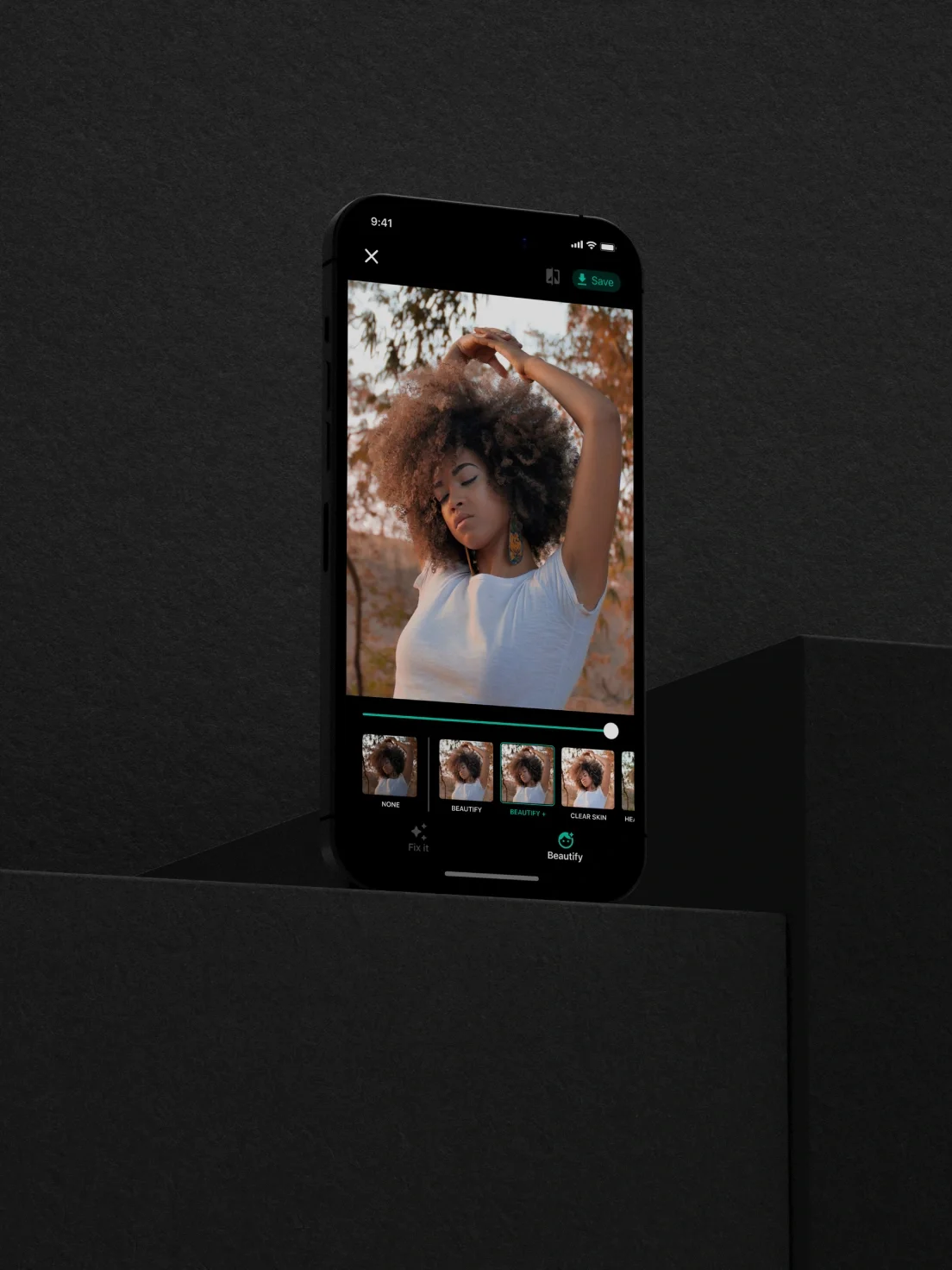 A smartphone displays the Perfectly Clear photo editing app with a portrait of a woman posing outdoors, adjusting her hair.