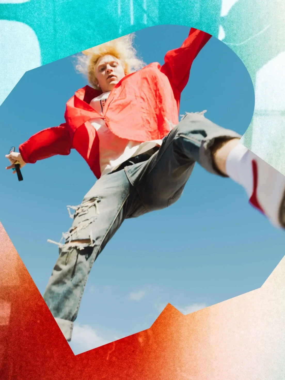 Person with blond hair in a red jacket jumps energetically, holding a microphone—embodying the bold Riff brand identity against the sky.