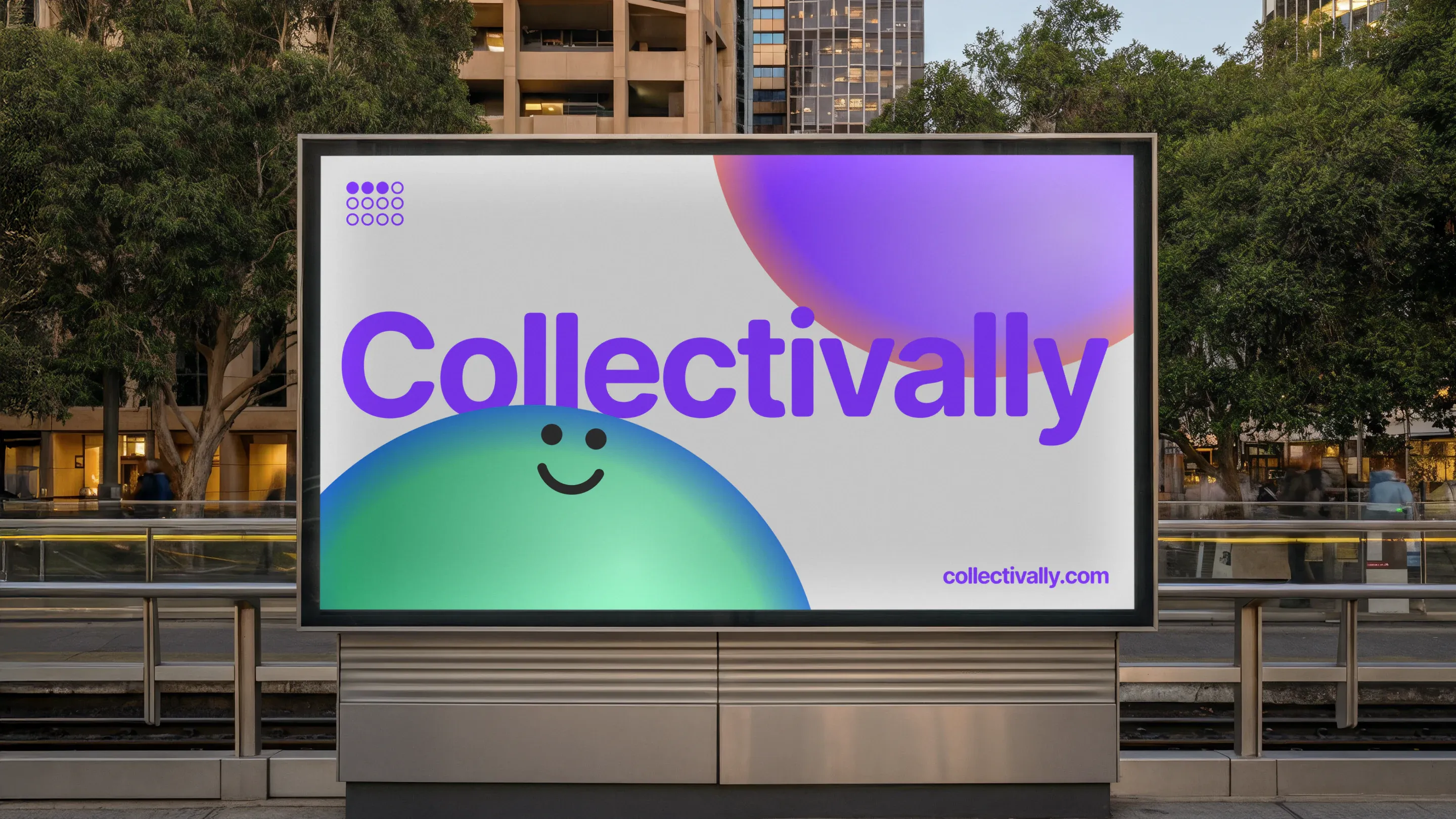 A Collectivally billboard in a city square at dusk, showing the wordmark in purple beside smiling gradient spheres, with trees and office buildings behind.