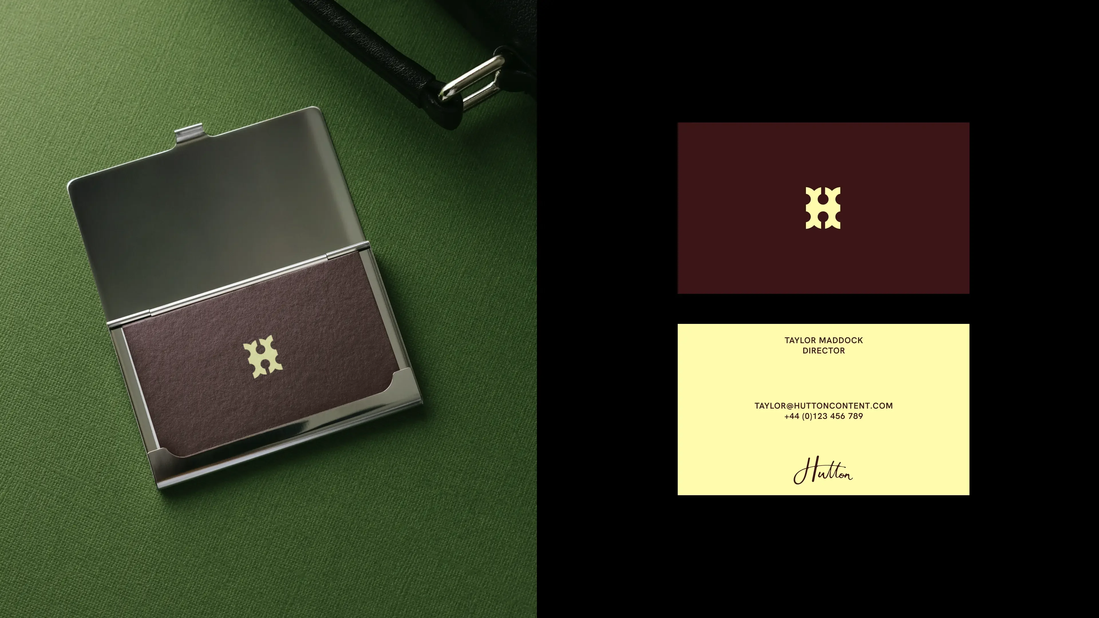 Hutton business cards. A burgundy card with the pale yellow monogram sits in a metal card case on green cloth, beside the two faces of the card: monogram on burgundy, contact details and signature on pale yellow