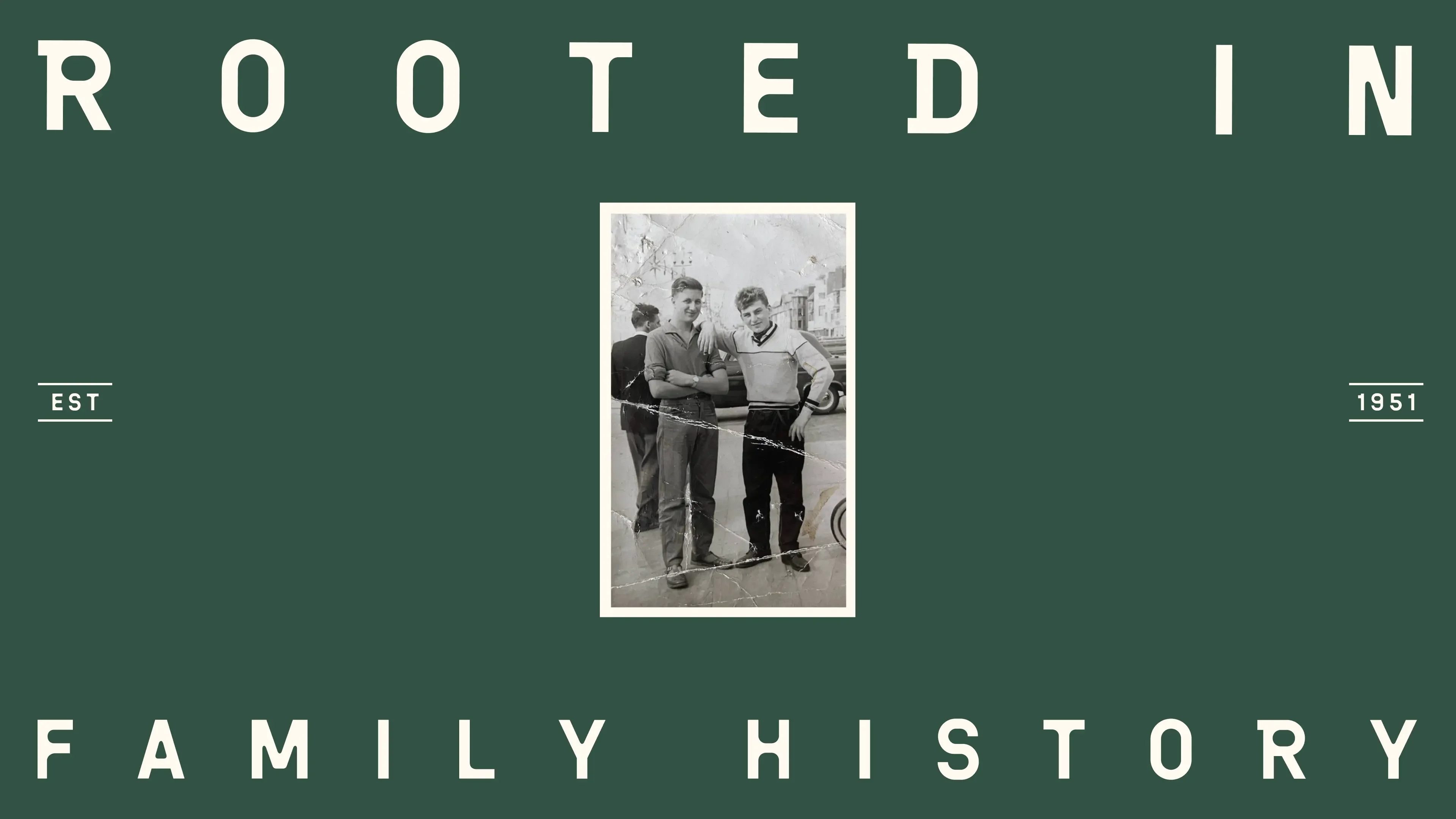 “Rooted in family history” in widely spaced capitals on forest green, around a creased black and white photograph of two young men, marked “Est 1951”